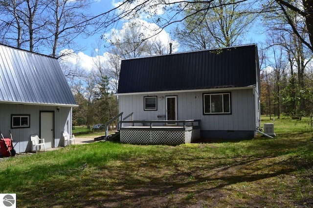 161 Huntinghorn Dr, Roscommon, MI 48653 - rear view of property with metal roof, central AC unit, a wooden deck, and a yard