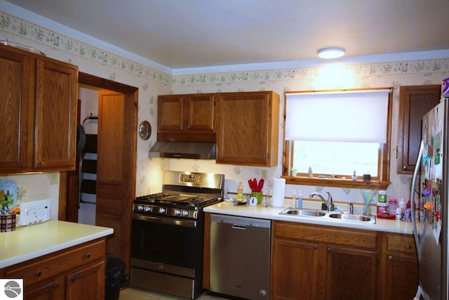 161 Huntinghorn Dr, Roscommon, MI 48653 - kitchen with stainless steel appliances, wallpapered walls, wall chimney range hood, a sink, and light countertops