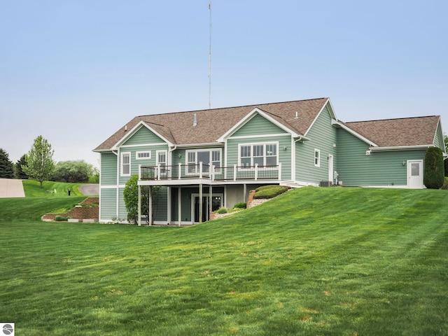 5199 Stonefield Dr Unit 13, Traverse City, MI 49684 - back of house with a deck, a lawn, and roof with shingles
