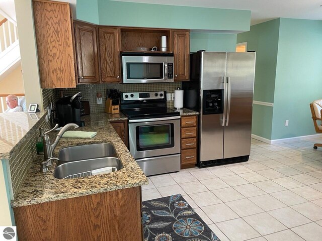 463 S Otis Ln, Au Gres, MI 48703 - kitchen featuring stainless steel appliances, a sink, tasteful backsplash, and light tile patterned floors
