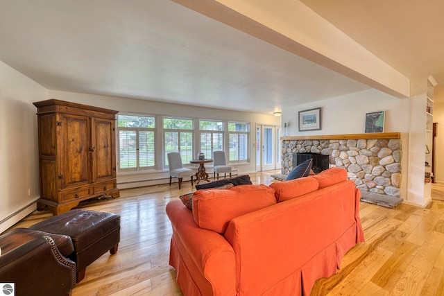 310 W Broadway, Suttons Bay, MI 49682 - living area with light wood finished floors, a stone fireplace, and a baseboard radiator
