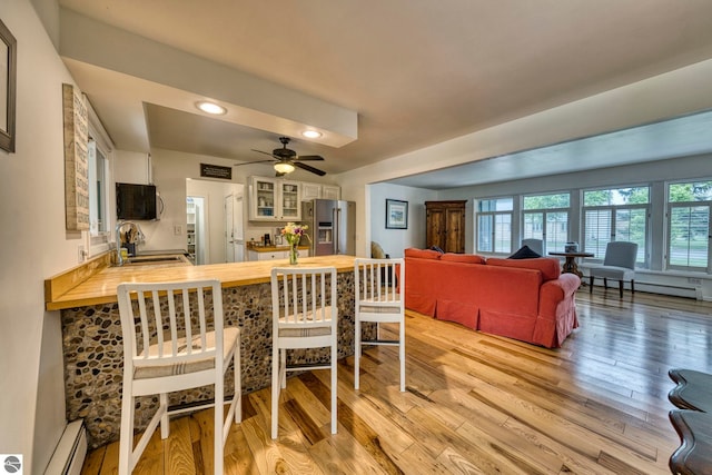 310 W Broadway, Suttons Bay, MI 49682 - dining room with baseboard heating, light wood-style floors, recessed lighting, and a ceiling fan