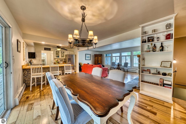 310 W Broadway, Suttons Bay, MI 49682 - dining space featuring a baseboard radiator, a chandelier, light wood-type flooring, and a ceiling fan