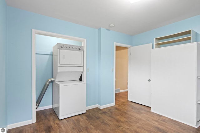 8695 S Maple City Rd, Maple City, MI 49664 - unfurnished bedroom with stacked washer / drying machine, wood finished floors, baseboards, and a closet