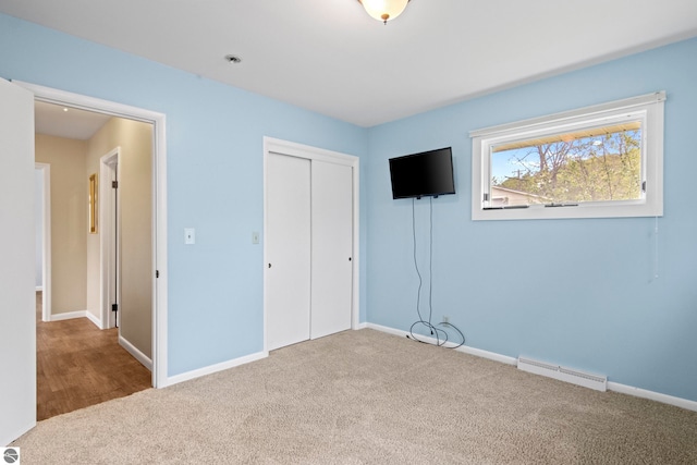 8695 S Maple City Rd, Maple City, MI 49664 - unfurnished bedroom featuring carpet flooring, a closet, and baseboards