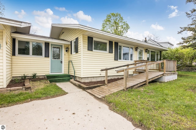 8695 S Maple City Rd, Maple City, MI 49664 - view of front of property with entry steps, a wooden deck, and a front lawn