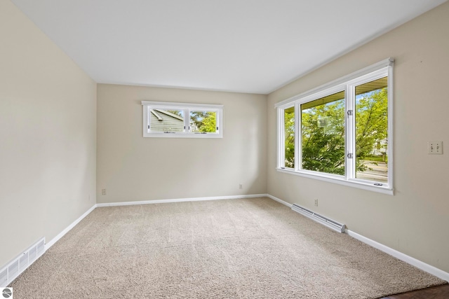 8695 S Maple City Rd, Maple City, MI 49664 - empty room featuring a baseboard heating unit, carpet flooring, and baseboards