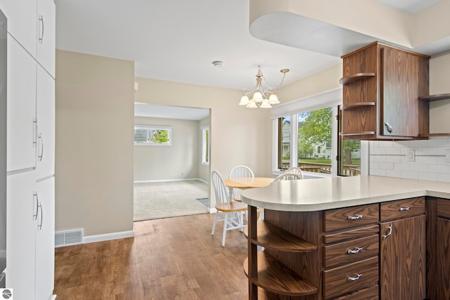 8695 S Maple City Rd, Maple City, MI 49664 - kitchen featuring open shelves, light countertops, healthy amount of natural light, and a peninsula