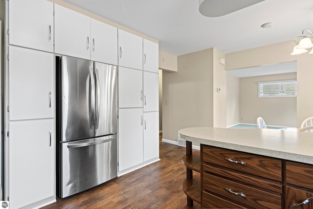 8695 S Maple City Rd, Maple City, MI 49664 - kitchen featuring freestanding refrigerator, dark wood-type flooring, light countertops, baseboards, and white cabinets