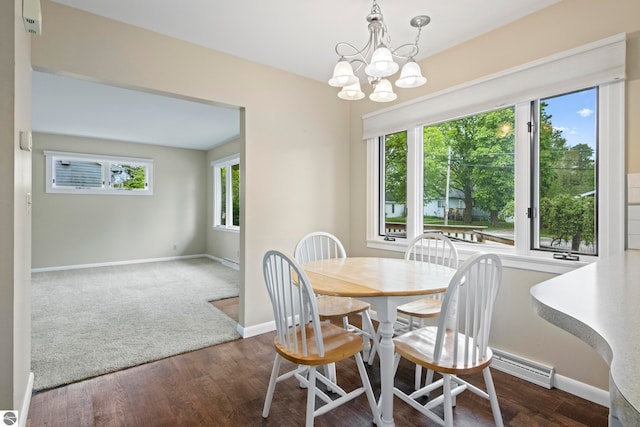 8695 S Maple City Rd, Maple City, MI 49664 - dining area featuring a chandelier, baseboards, and wood finished floors