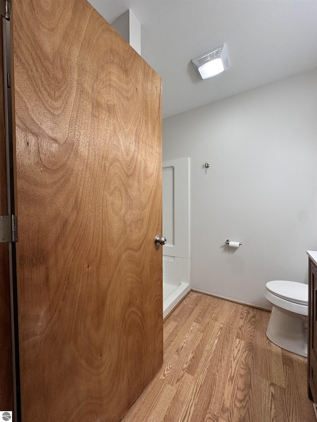 4872 E Shore Dr NE, Kalkaska, MI 49646 - bathroom featuring wood finished floors, toilet, and vanity