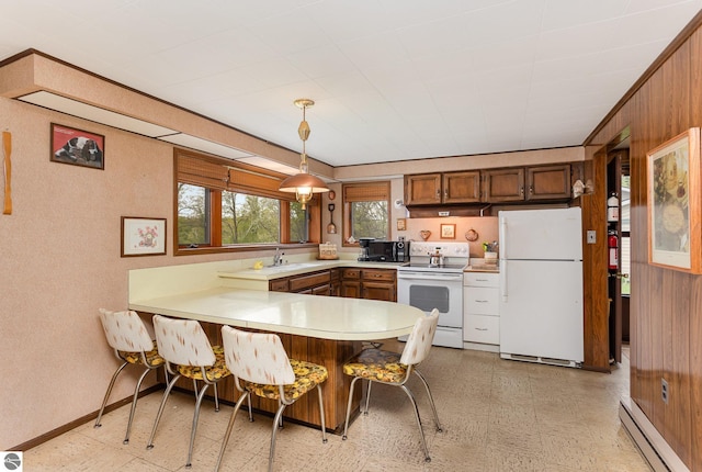 4645 Lakeview Dr, Hale, MI 48739 - kitchen with white appliances, a baseboard radiator, light flooring, a peninsula, and light countertops