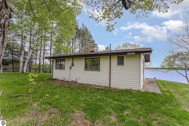4645 Lakeview Dr, Hale, MI 48739 - view of property exterior with a lawn, a chimney, and a water view