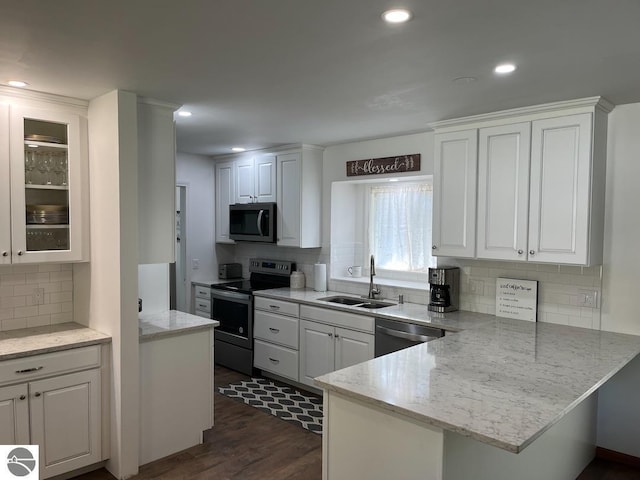 302 Huron St, Traverse City, MI 49686 - kitchen with stainless steel appliances, a sink, white cabinets, and recessed lighting