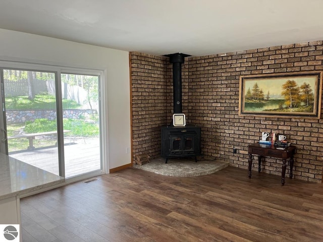 302 Huron St, Traverse City, MI 49686 - unfurnished living room featuring a wood stove, wood finished floors, and baseboards