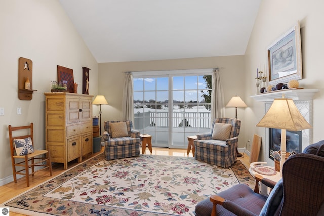 6200 Single Tree Ln, Williamsburg, MI 49690 - living room featuring wood finished floors, baseboards, high vaulted ceiling, and a water view