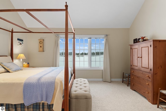 6200 Single Tree Ln, Williamsburg, MI 49690 - bedroom featuring light carpet, a water view, lofted ceiling, and baseboards