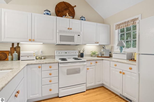 6200 Single Tree Ln, Williamsburg, MI 49690 - kitchen with white appliances, vaulted ceiling, white cabinetry, light wood finished floors, and light stone countertops