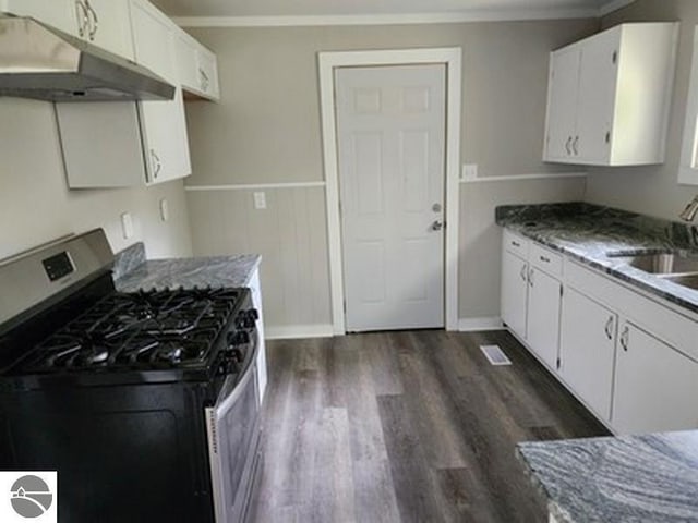 2620 N Huron, Tawas City, MI 48763 - kitchen with stainless steel range with gas cooktop, under cabinet range hood, crown molding, dark wood-style flooring, and white cabinetry