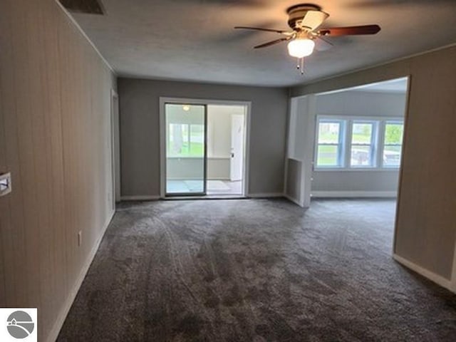 2620 N Huron, Tawas City, MI 48763 - empty room with carpet, a ceiling fan, baseboards, and wooden walls