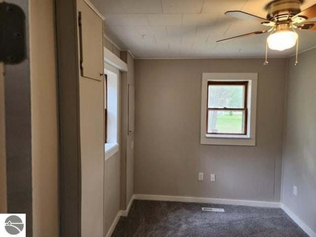 2620 N Huron, Tawas City, MI 48763 - empty room featuring dark carpet, a ceiling fan, and baseboards