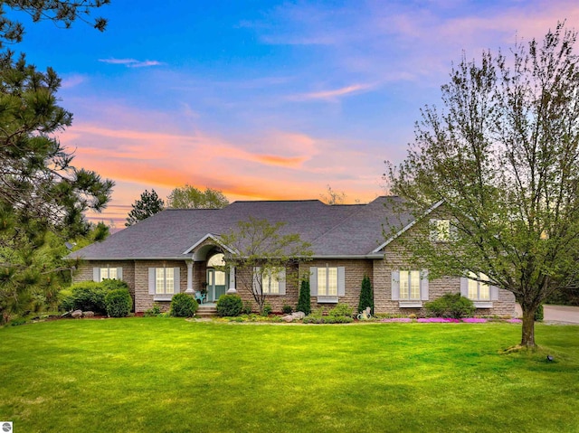 8575 Stardust Cir, Cadillac, MI 49601 - view of front facade featuring a front yard, roof with shingles, and brick siding