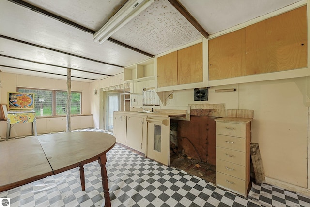 1151 N 8 Mile Rd, Lake City, MI 49651 - kitchen with tile patterned floors, a sink, light countertops, and beamed ceiling