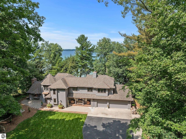 4283 Maitland Rd, Williamsburg, MI 49690 - view of front of home with a chimney, asphalt driveway, a front lawn, and a garage