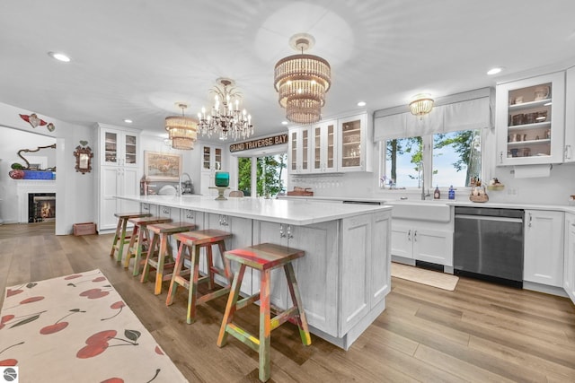 4283 Maitland Rd, Williamsburg, MI 49690 - kitchen featuring stainless steel dishwasher, recessed lighting, light countertops, a breakfast bar area, and white cabinetry