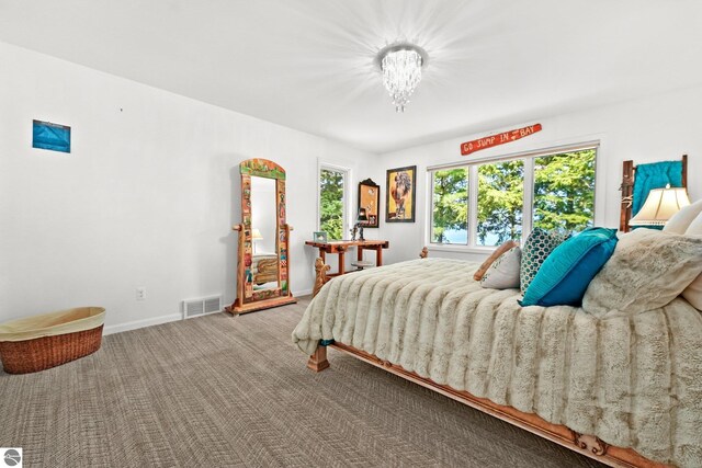 4283 Maitland Rd, Williamsburg, MI 49690 - bedroom with carpet flooring, baseboards, and a chandelier