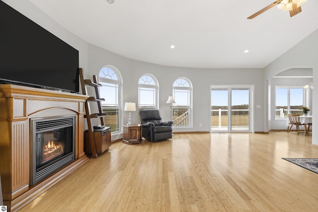 2769 White Rd, Frankfort, MI 49635 - living area with light wood-style flooring, a glass covered fireplace, arched walkways, ceiling fan, and recessed lighting