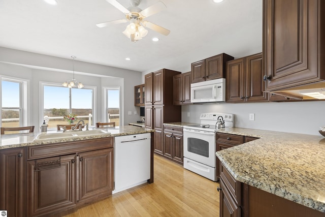 2769 White Rd, Frankfort, MI 49635 - kitchen featuring white appliances, a sink, light wood-type flooring, recessed lighting, and hanging light fixtures