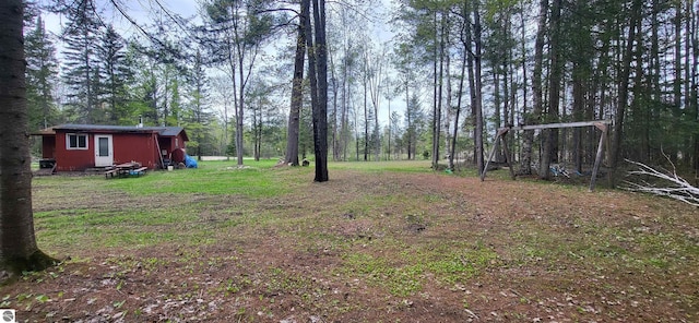 6031 Collins Rd, Onaway, MI 49765 - view of green lawn featuring an outdoor structure and a view of trees