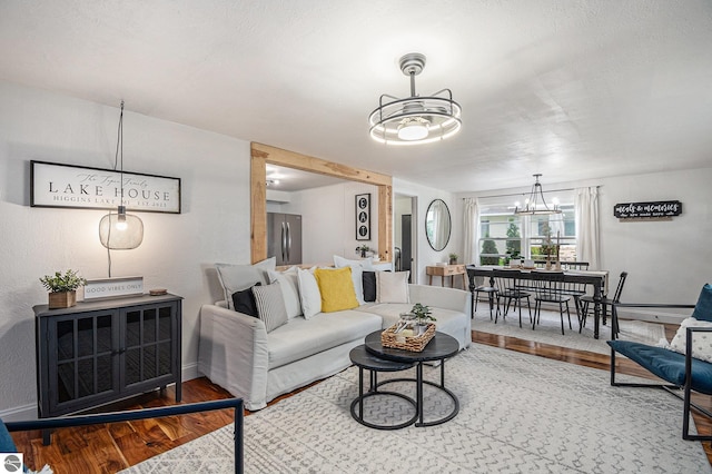 104 Haines Ave, Roscommon, MI 48653 - living room with wood finished floors, a chandelier, and baseboards