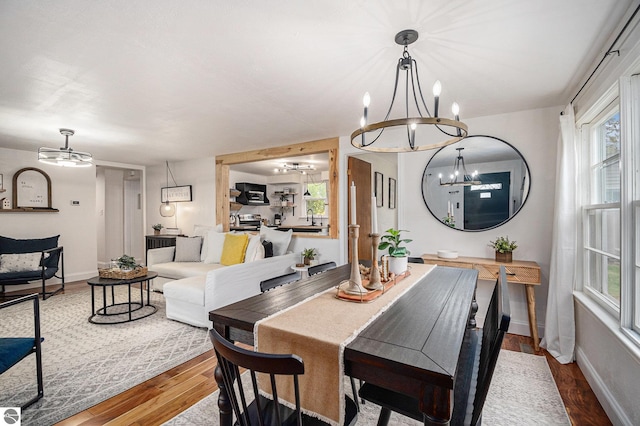 104 Haines Ave, Roscommon, MI 48653 - dining space featuring a chandelier, wood finished floors, and baseboards