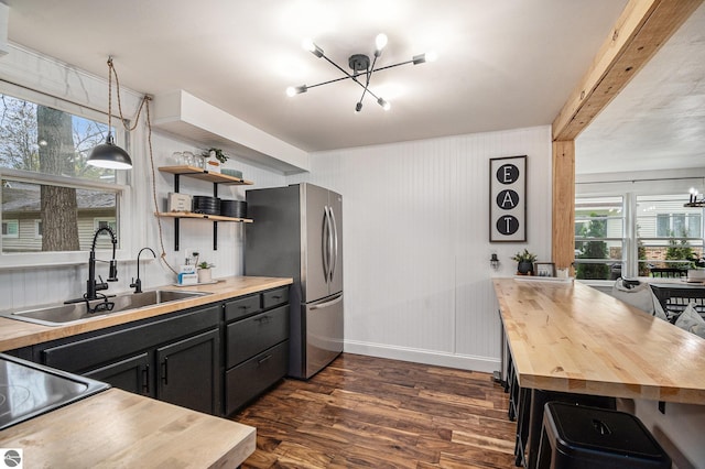 104 Haines Ave, Roscommon, MI 48653 - kitchen featuring a chandelier, freestanding refrigerator, butcher block counters, and a sink