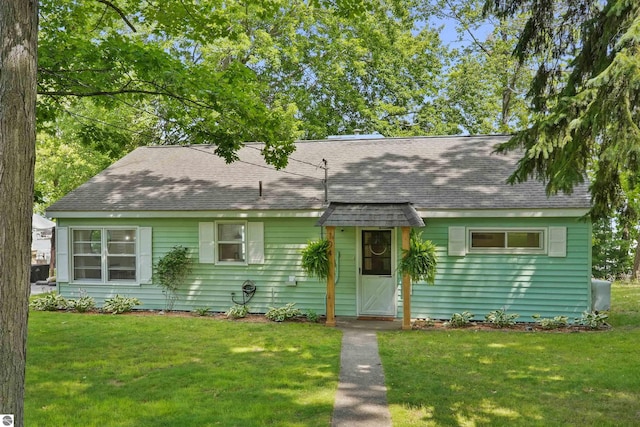 104 Haines Ave, Roscommon, MI 48653 - new england style home with roof with shingles and a front yard