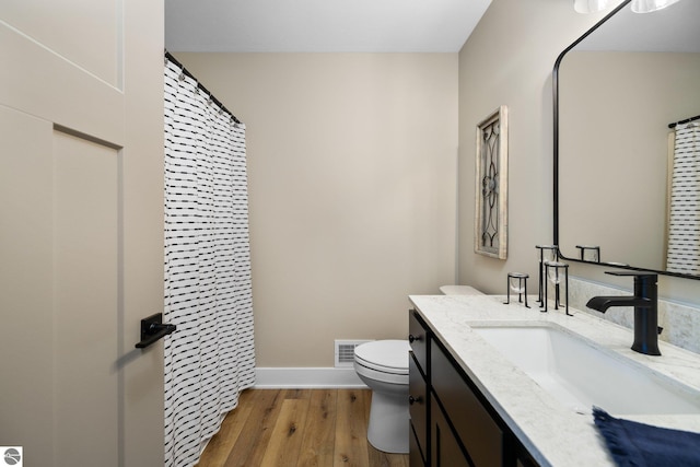 11964 E Shaker Trl, Suttons Bay, MI 49682 - bathroom with toilet, vanity, wood finished floors, baseboards, and a shower with curtain