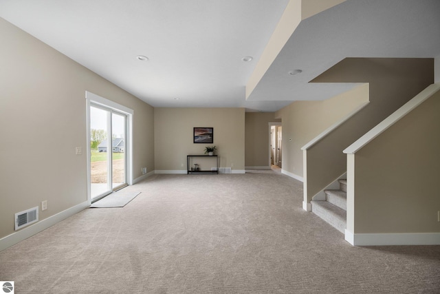 11964 E Shaker Trl, Suttons Bay, MI 49682 - unfurnished living room featuring light colored carpet, stairway, baseboards, and recessed lighting
