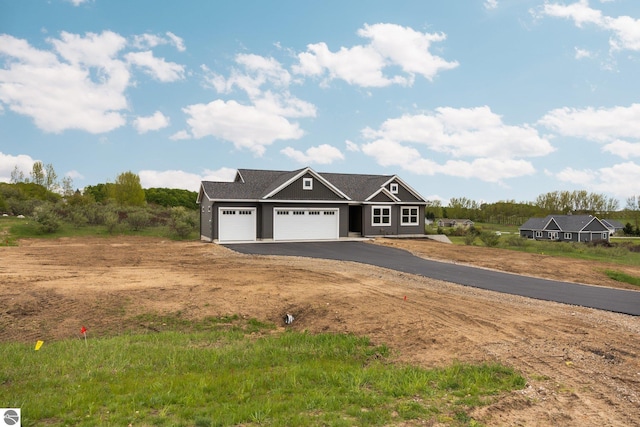 11964 E Shaker Trl, Suttons Bay, MI 49682 - view of front facade featuring an attached garage and asphalt driveway