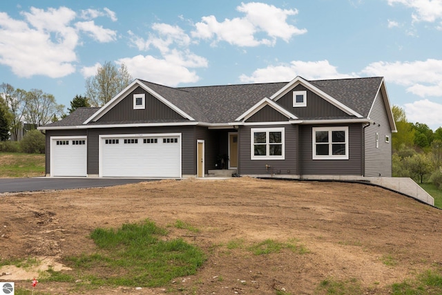 11964 E Shaker Trl, Suttons Bay, MI 49682 - craftsman house featuring an attached garage, asphalt driveway, roof with shingles, and board and batten siding