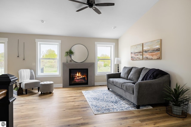 11964 E Shaker Trl, Suttons Bay, MI 49682 - living area featuring healthy amount of natural light, a ceiling fan, a glass covered fireplace, light wood-type flooring, and lofted ceiling