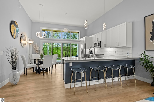 8906A Manhattan N Unit A, Traverse City, MI 49685 - kitchen with stainless steel appliances, a sink, a breakfast bar area, decorative backsplash, and a towering ceiling