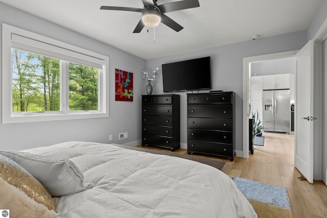 8906A Manhattan N Unit A, Traverse City, MI 49685 - bedroom with stainless steel fridge, light wood-style floors, ceiling fan, and baseboards