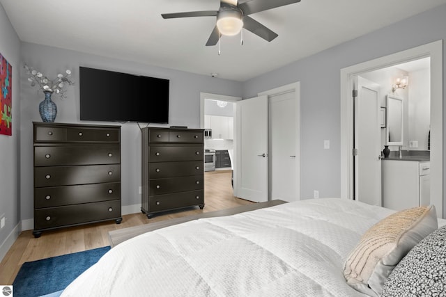 8906A Manhattan N Unit A, Traverse City, MI 49685 - bedroom with light wood-style flooring, baseboards, connected bathroom, and ceiling fan