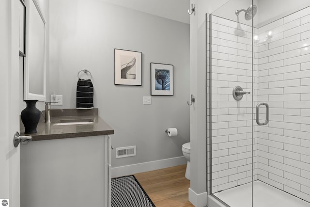 8906A Manhattan N Unit A, Traverse City, MI 49685 - bathroom featuring vanity, a shower stall, toilet, wood finished floors, and baseboards