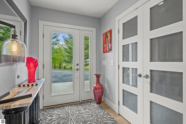 8906A Manhattan N Unit A, Traverse City, MI 49685 - doorway to outside with french doors, light wood-type flooring, and baseboards