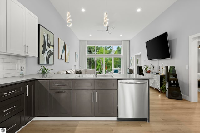 8906A Manhattan N Unit A, Traverse City, MI 49685 - kitchen featuring dishwasher, a sink, white cabinetry, ceiling fan, and a peninsula