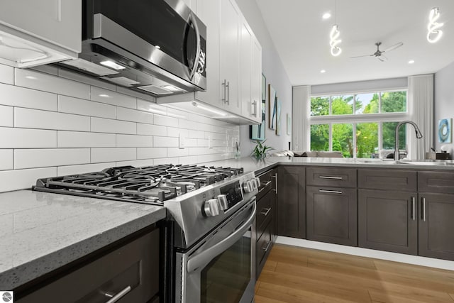 8906A Manhattan N Unit A, Traverse City, MI 49685 - kitchen featuring appliances with stainless steel finishes, light stone countertops, backsplash, and a ceiling fan