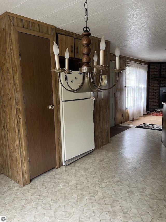 118 W Huron, Omer, MI 48749 - unfurnished dining area featuring wood walls and a textured ceiling